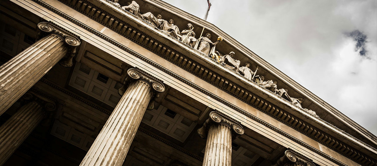 CSRD-Umsetzungsgesetz – Regierungsentwurf veröffentlicht Perspektivische Aufnahme eines historischen Gebäudes mit antiken Säulen und Figuren auf dem Giebel.
